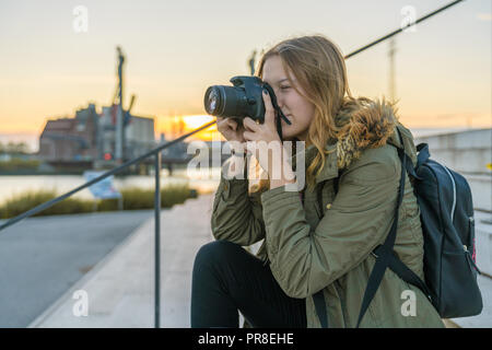 Young woman is taking a picture with a dslr camera Stock Photo