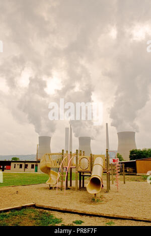2007 - Coal powered company cooling tower behind a school playground Stock Photo