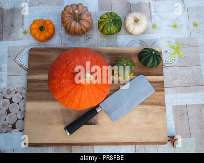 Top down view of imagine with pumpkins and axe on a wooden board Stock Photo