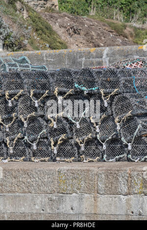 Harbour scenes around Newquay, Cornwall. Lobster / crab pots stacked on harbour quayside. Stock Photo