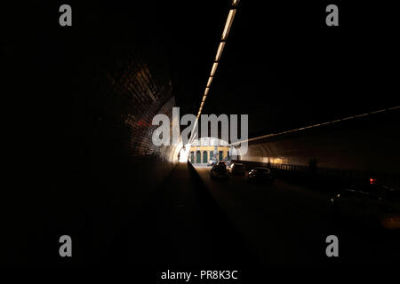 Perspective view through the dark tunnel of Ribeira (Porto, Portugal) seeing traffic and interesting light Stock Photo