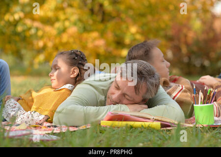 Happy family resting in park with book Stock Photo