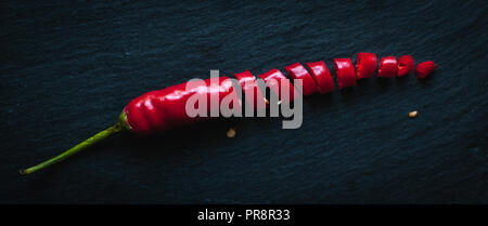 Chopped red chili pepper on dark background, top view Stock Photo