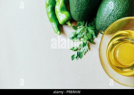Pair of avocados with an oil in a cup of glass over a brown background above view selective focus selective focus Stock Photo