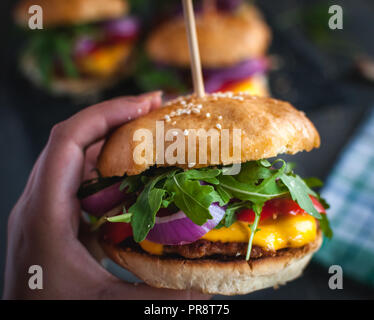 Close-up of hand holding homemade fresh burger Stock Photo