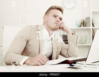 Frustrated young man having business problems with papers at workplace Stock Photo