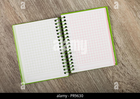 Open notebook lying on wooden surface Stock Photo