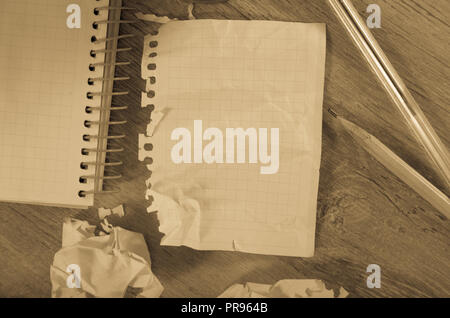 Crumpled empty pages and notebook lying on wooden surface Stock Photo
