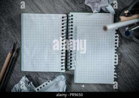 Crumpled empty pages and notebook lying on wooden surface Stock Photo