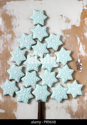 Decorative Christmas tree made of ginger biscuits and cinnamon on a light wooden background, postcard. Selective focus. Stock Photo