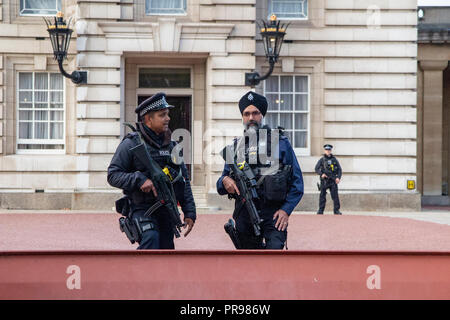 A sikh (or siqh) policeman in a turban and a muslim policeman outside Buckingham Palace Stock Photo