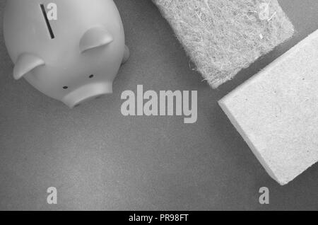 terracotta piggy bank and wall insulation panel on a stone background - top view Stock Photo