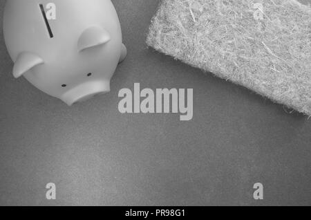 terracotta piggy bank and wall insulation panel on a stone background - top view Stock Photo