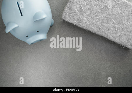 terracotta piggy bank and wall insulation panel on a stone background - top view Stock Photo