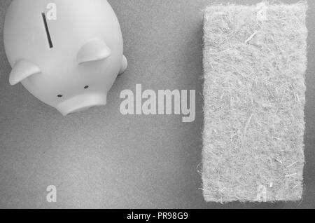 terracotta piggy bank and wall insulation panel on a stone background - top view Stock Photo