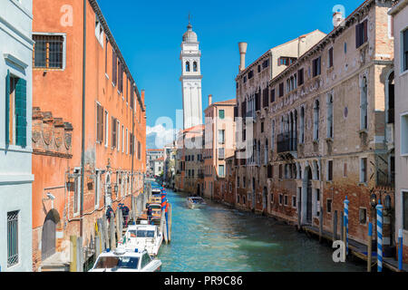 Old canal in Venice with boats parked near of residential buildings, Italy Stock Photo