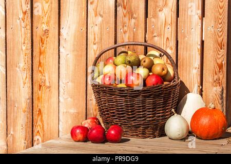 Wicker basket with apples and pears. Autumn harvest of fruit. Fresh fruit in a basket Stock Photo