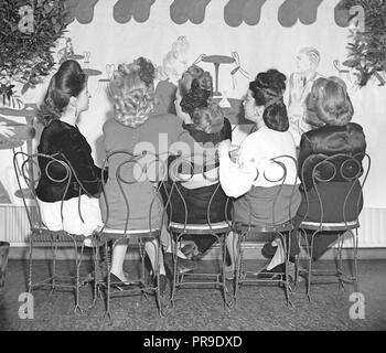 Hairstyles of the 1940s. A group of five young women are pictured from behind when sitting together. The women have had their hair done in different typical 1940s hairstyles.   Sweden 1946. Photo Kristoffersson ref V128-5 Stock Photo