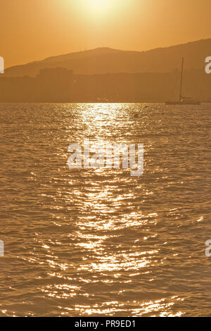 Golden sunshine with stars and sparkles background in the ocean at sunset on a beautiful afternoon in September in Mallorca, Spain. Stock Photo