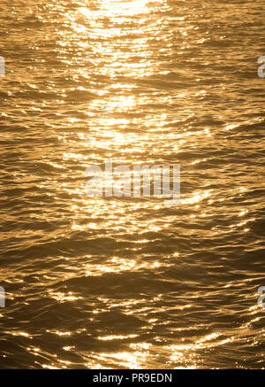 Golden sunshine with stars and sparkles background in the ocean at sunset on a beautiful afternoon in September in Mallorca, Spain. Stock Photo