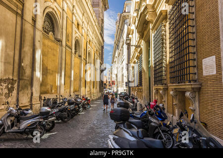 Rome/Italy - August 26, 2018: Roman street with scooters parked on the back of Santa Maria in Via Lata Stock Photo