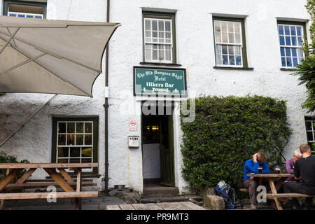 Hillwalkers relaxing drinking beer outside the Old Dungeon Ghyll Hotel Hikers Bar, Great Langdale, Lake District, Cumbria, England. Stock Photo