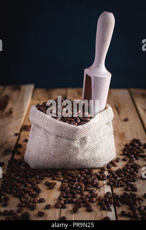 Coffee beans in jute sack on wooden background Stock Photo