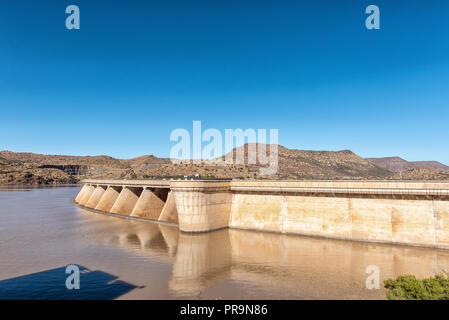 Wall of the Vanderkloof Dam in the Orange River. The road to the Vanderkloof town in the Northern Cape Province is visible on the hills in the back Stock Photo