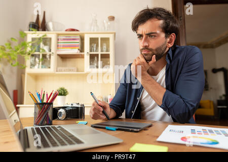 Graphic designer working on digital tablet. Freelancer working at home. Stock Photo