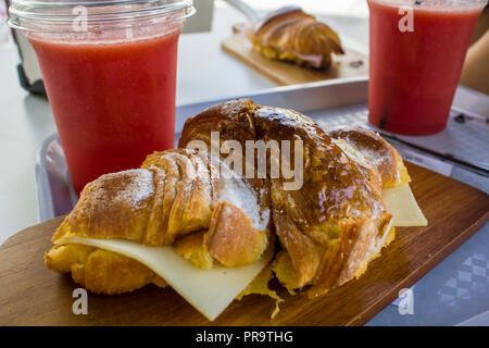 Freshly baked Croissant with cheese and natural watermelon juice on a plastic cup Stock Photo