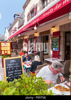 BRITTANY  Blackboard menu Creperie and Bretonne Biers outside  alfresco French restaurant with diner & crepes in foreground Concarneau Bretagne France Stock Photo