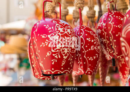 Ornate red souvenir cow bells for sale on  a souvenir stand in Salzburg, Austria Stock Photo