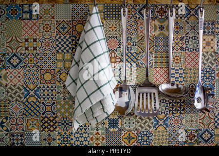 Kitchen utensils and Kitchen Towel hanging on kitchen wall Stock Photo