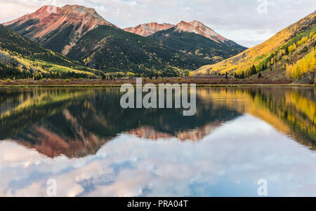 Pink clouds reflected in Crystal Lake below the Red Mountains in Autumn in the Uncompahgre National Forest south of Ouray, Colorado. Stock Photo