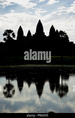 Silhouette of ruins reflected in the water at sunrise in Angkor Wat. The Angkor Wat complex, Built during the Khmer Empire age, located in Siem Reap,  Stock Photo