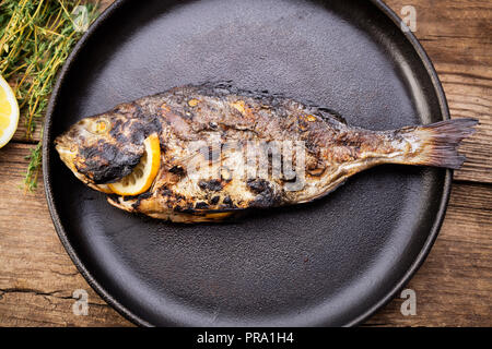 grilled glit-head fish on pan with vegetables Stock Photo