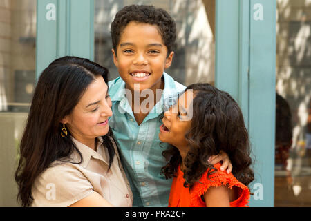 Happy Hispnaic mother laughing and talking with her children. Stock Photo