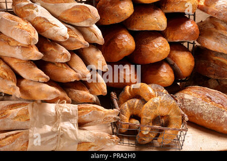 Different types of bread and buns in a metal basket on a wooden background Stock Photo