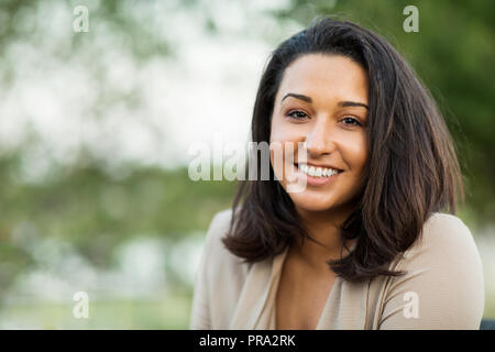 Young confident happy Hispanic woman smiling outside. Stock Photo