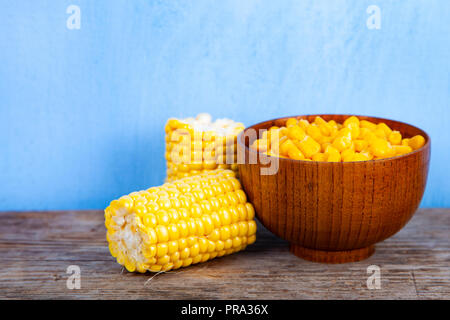 Ripe corn in a bowl on a wooden table. Stock Photo