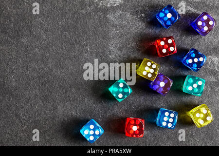 Colorful dice on a dark background, selective focus, space for text. Stock Photo