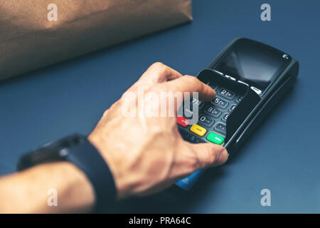 credit card purchase at store hand entering pin code Stock Photo