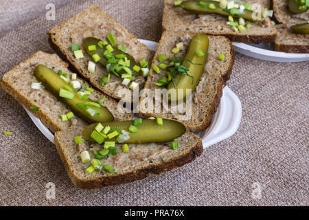 Homemade lard and pickled gherkin on a slices of bread. Traditional rural cuisine. Stock Photo