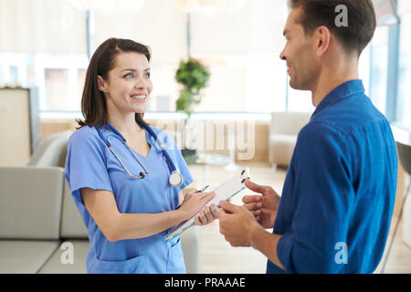 Smiling Nurse Talking to Patient Stock Photo