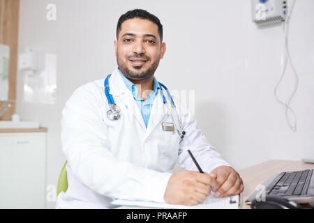 Middle-Eastern Doctor Posing at Workplace Stock Photo