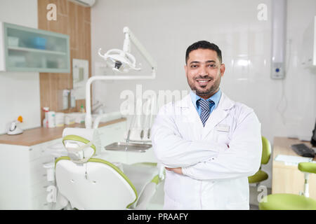 Middle-Eastern Dentist Posing at Workplace Stock Photo