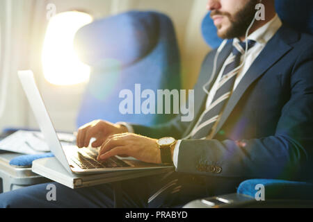 Businessman Using Laptop in Plane Closeup Stock Photo