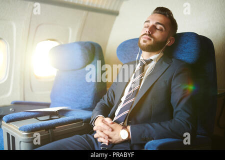 Handsome Businessman Sleeping in Plane Stock Photo