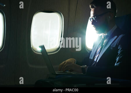 Businessman Working in Flight Stock Photo