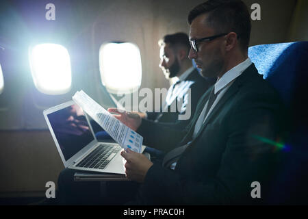 Row of Business People in Plane Stock Photo